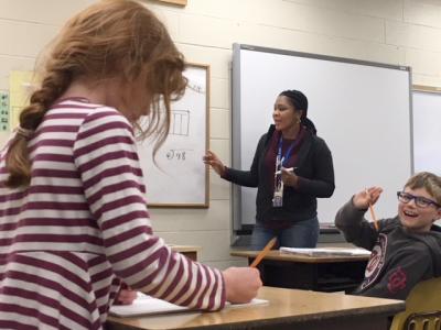 A photo of Anice Denton works with students during class.
